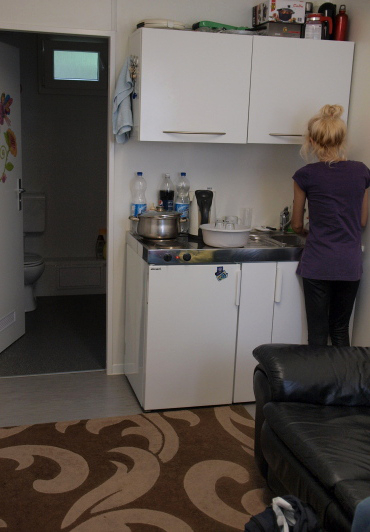 This is the first room of one container where family members have to sleep in front of the sofa at night.